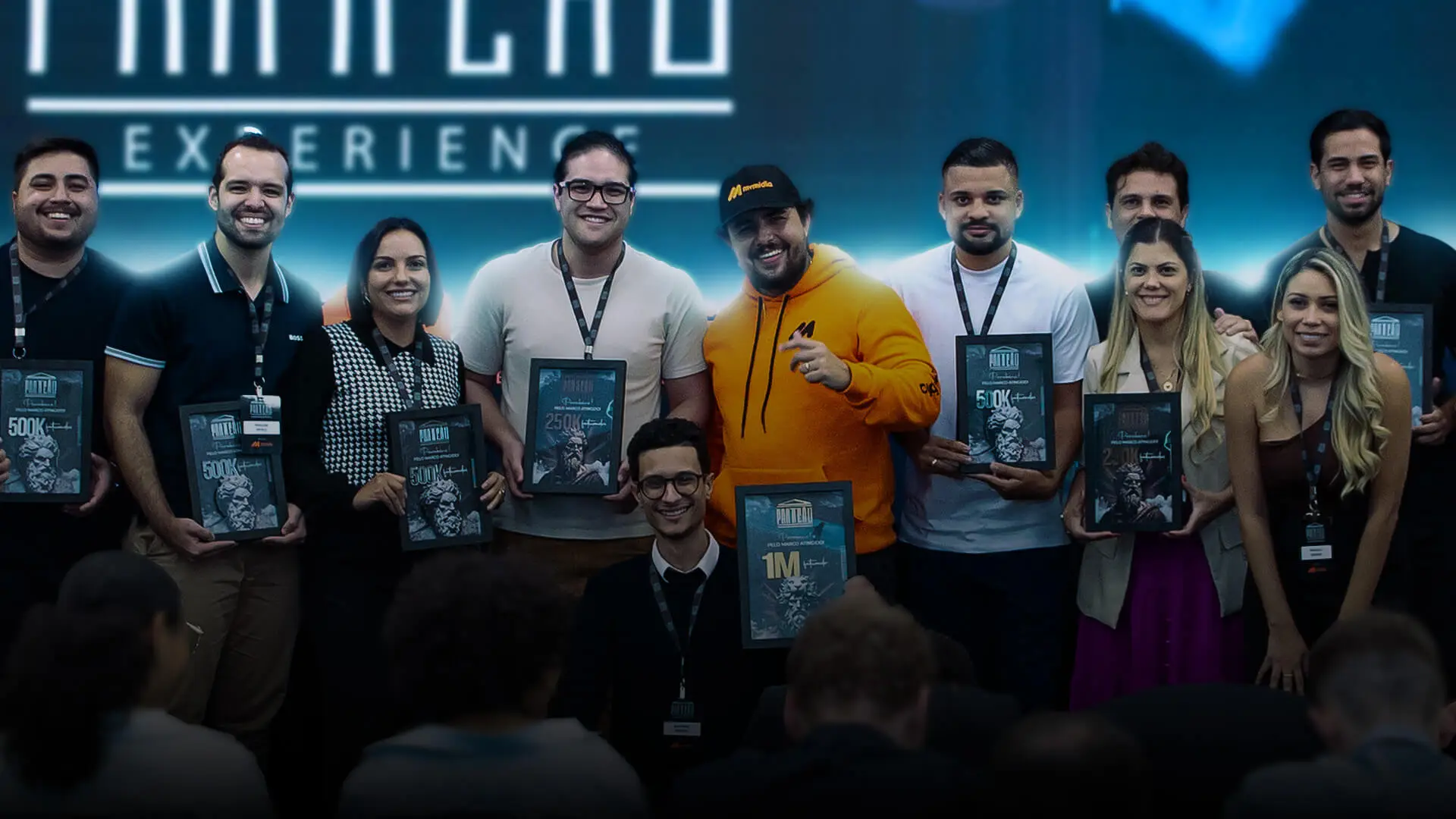 Comunidade reunida com placas de reconhecimento no Panteão Experience